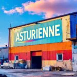 Entrepôt aux couleurs vives avec logo Asturienne et palettes