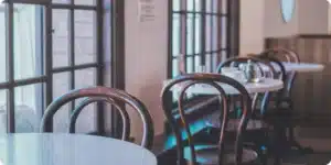 Chaises bistrot vintage en bois courbé alignées dans un café, dossier arrondi en hêtre patiné