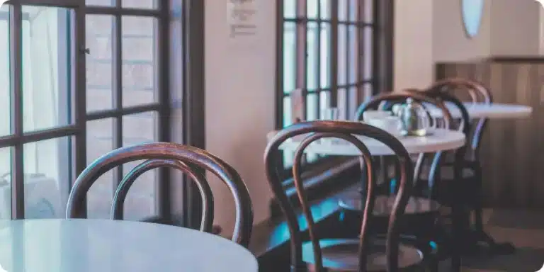 Chaises bistrot vintage en bois courbé alignées dans un café, dossier arrondi en hêtre patiné