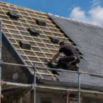 Chantier de réfection de toiture avec échafaudage et couvreur au travail