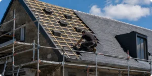 Chantier de réfection de toiture avec échafaudage et couvreur au travail