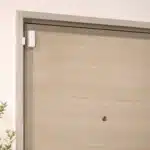Porte d'entrée d'appartement équipée d'un capteur magnétique d'alarme adhésif discret sur la huisserie