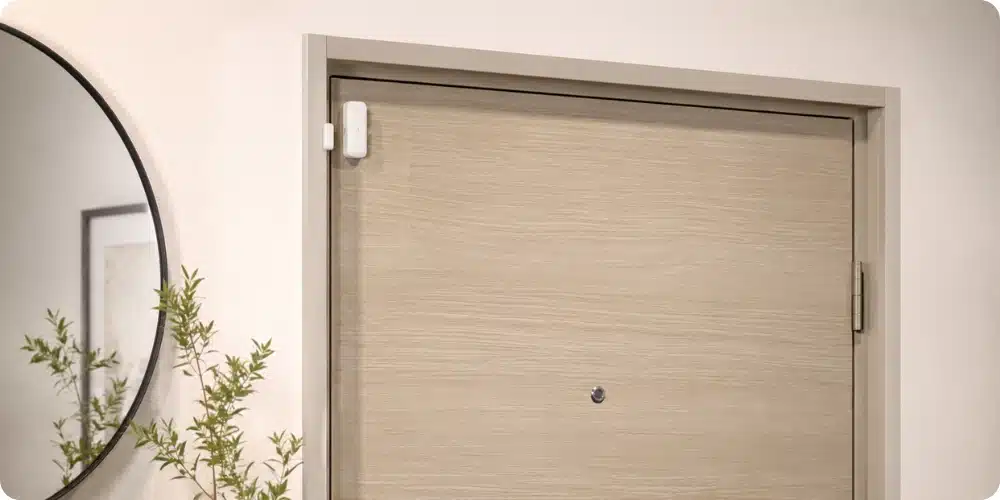 Porte d'entrée d'appartement équipée d'un capteur magnétique d'alarme adhésif discret sur la huisserie