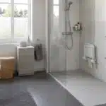 Salle de bain adaptée pour senior avec douche de plain-pied, barres d'appui et sol antidérapant