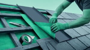Ouvrier installant une membrane d'étanchéité et une plaque métallique sur une toiture en pente.