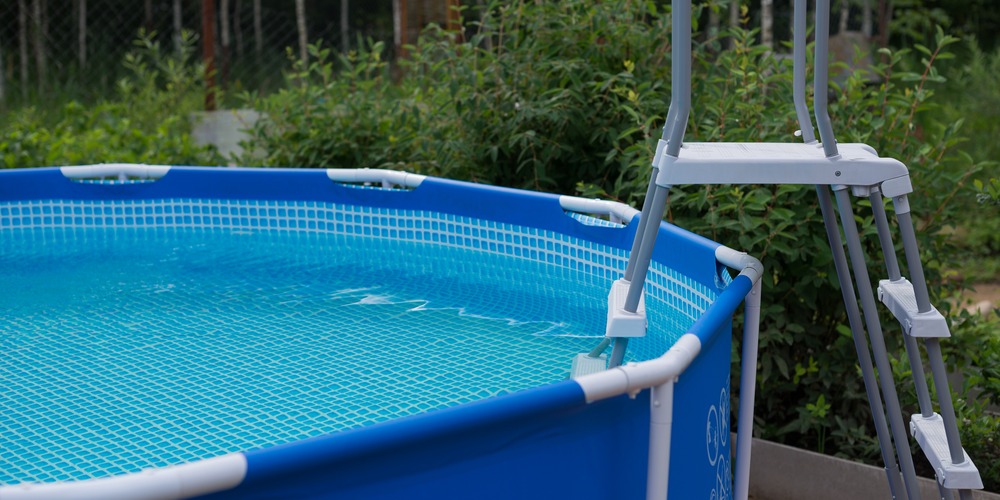 Échelle posée contre une piscine hors sol tubulaire, à retirer après la baignade pour condamner l'accès au bassin